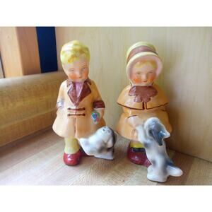 Coventry USA glazed ceramic figurines depicting a boy and a girl, With dogs.